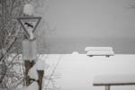 Bank im Schnee mit Schild